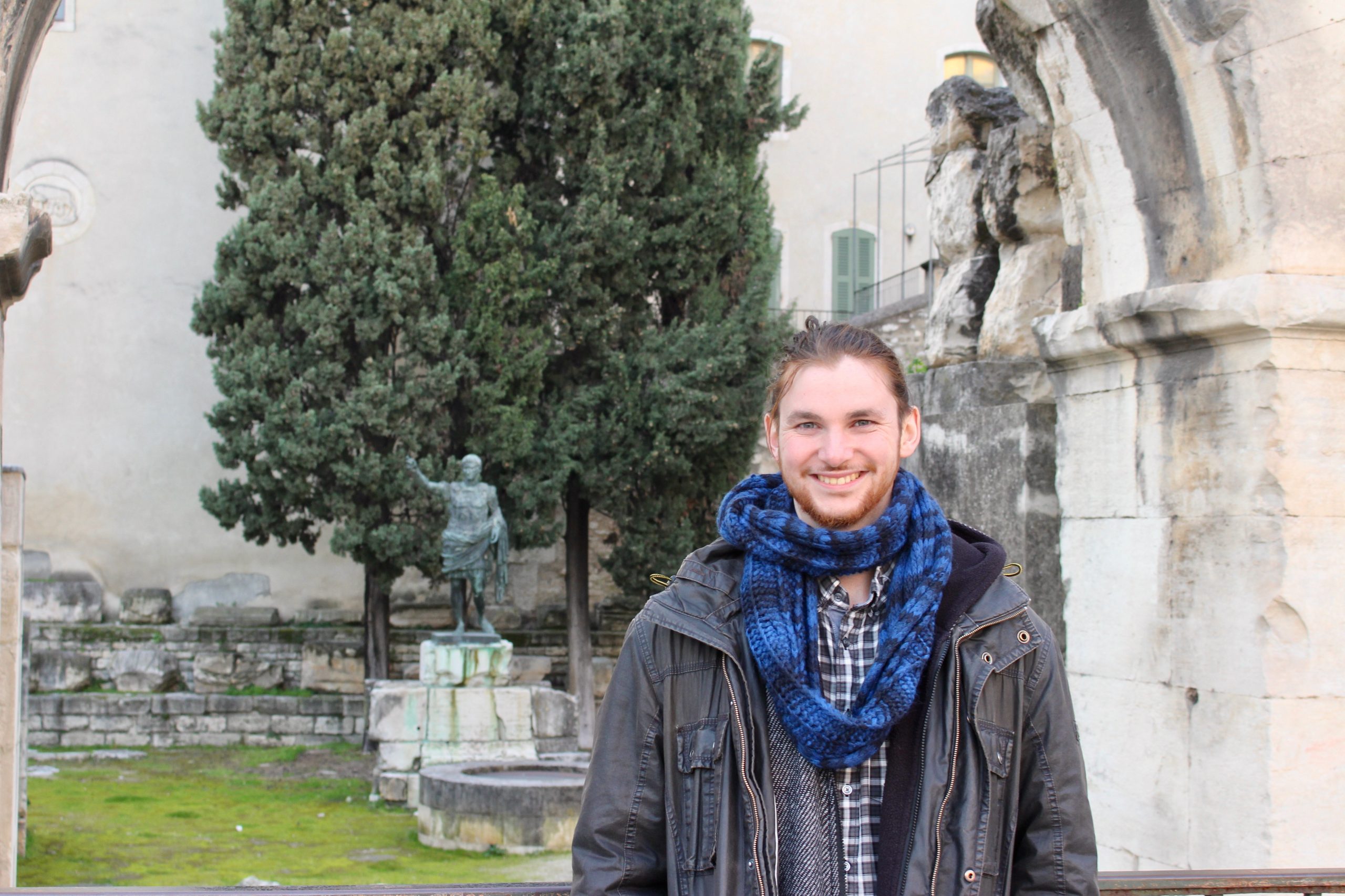 A person in front of Roman ruins