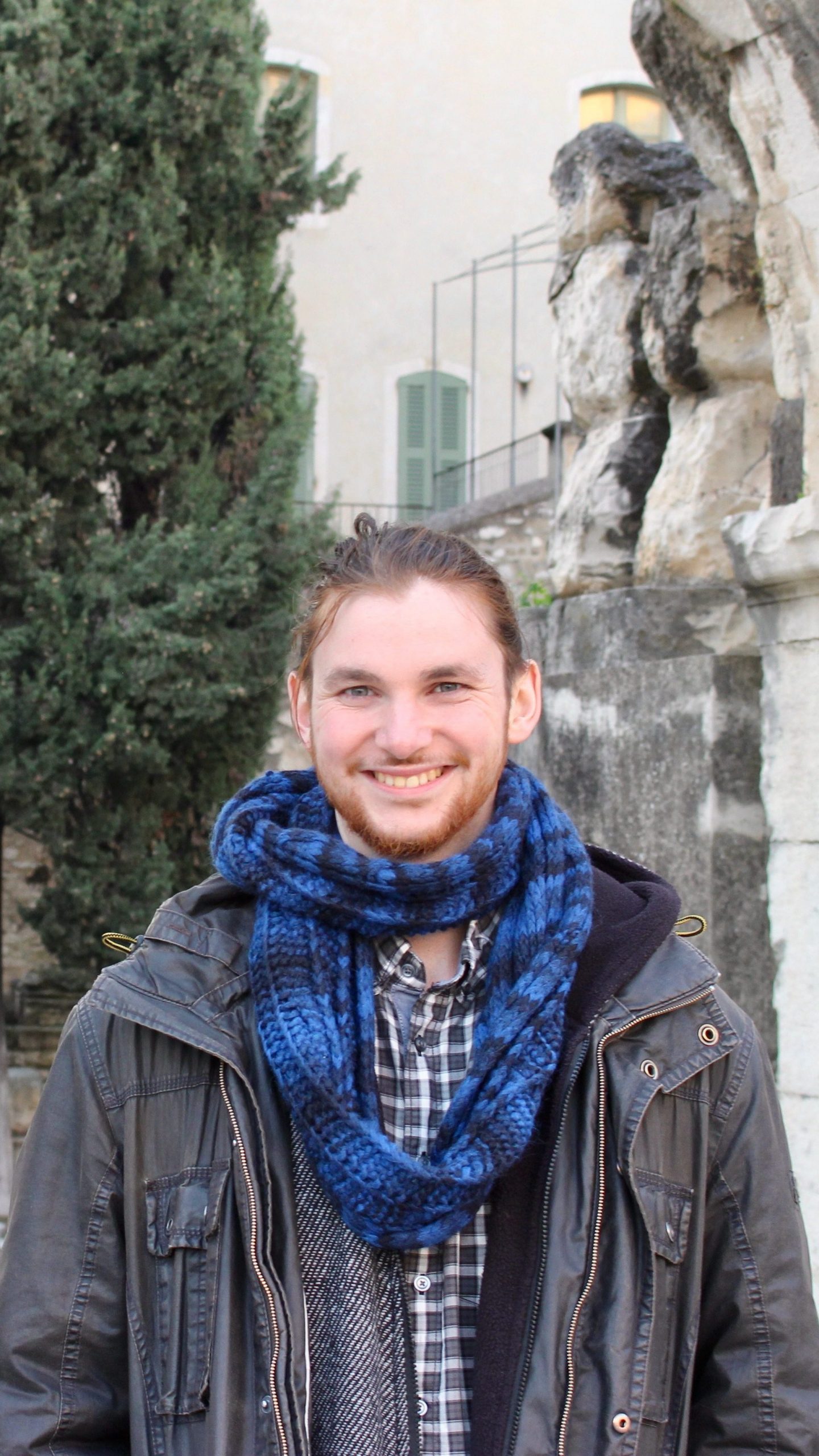 A person in front of Roman ruins